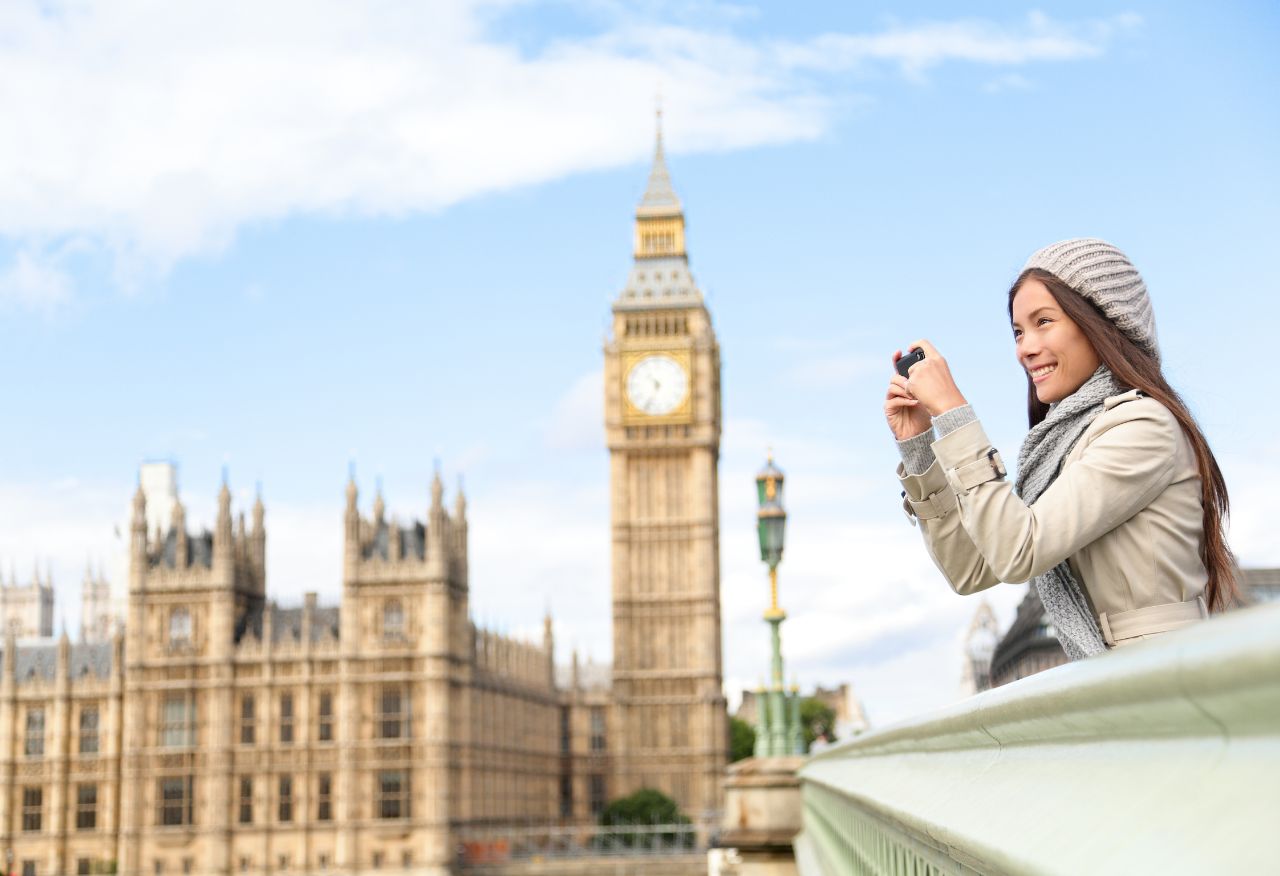 Female traveler taking photos on a bridge near Westminster.